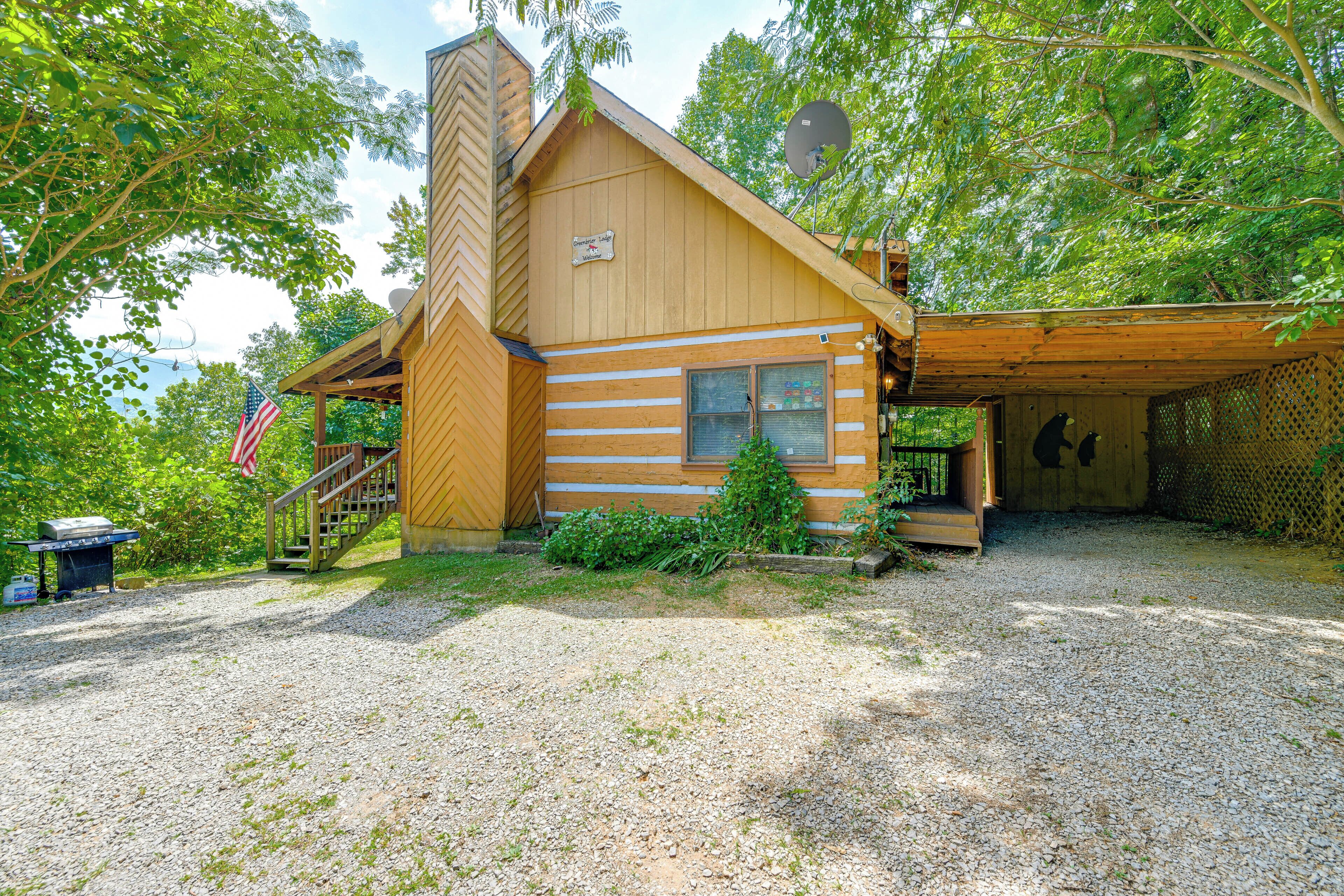A rustic cabin with a chimney, a porch, and a covered area.