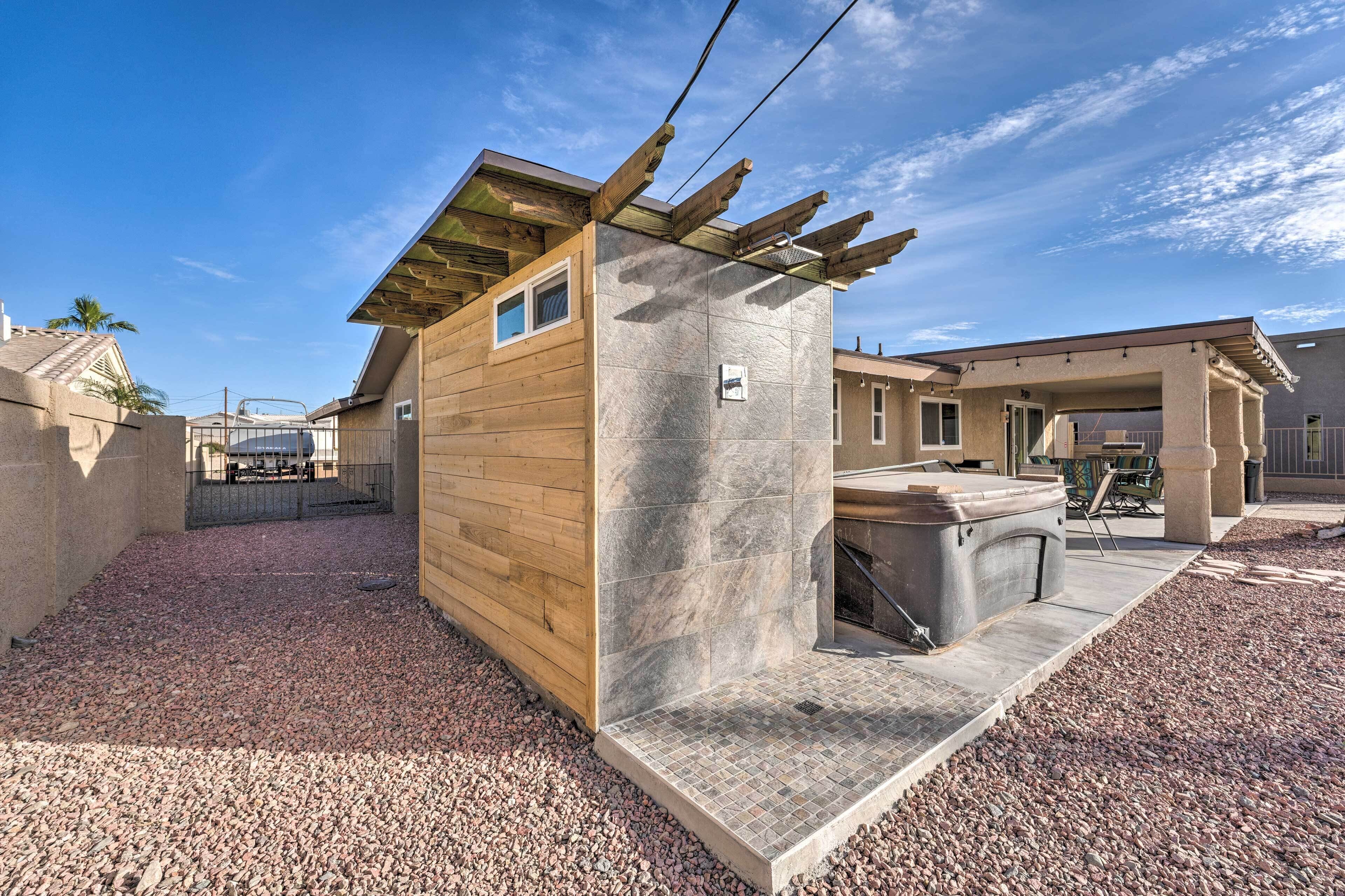 Un bâtiment moderne doté d’un revêtement extérieur en bois et d’une façade en pierre, comprenant un patio avec un barbecue.