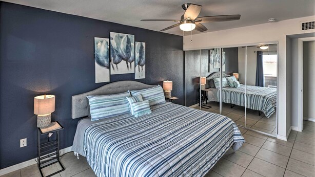 A modern bedroom with a large bed, a ceiling fan, and artwork on the wall. - 2 Mi to Dtwn: Lake Havasu City Oasis w/ Pool (Lake Havasu City)