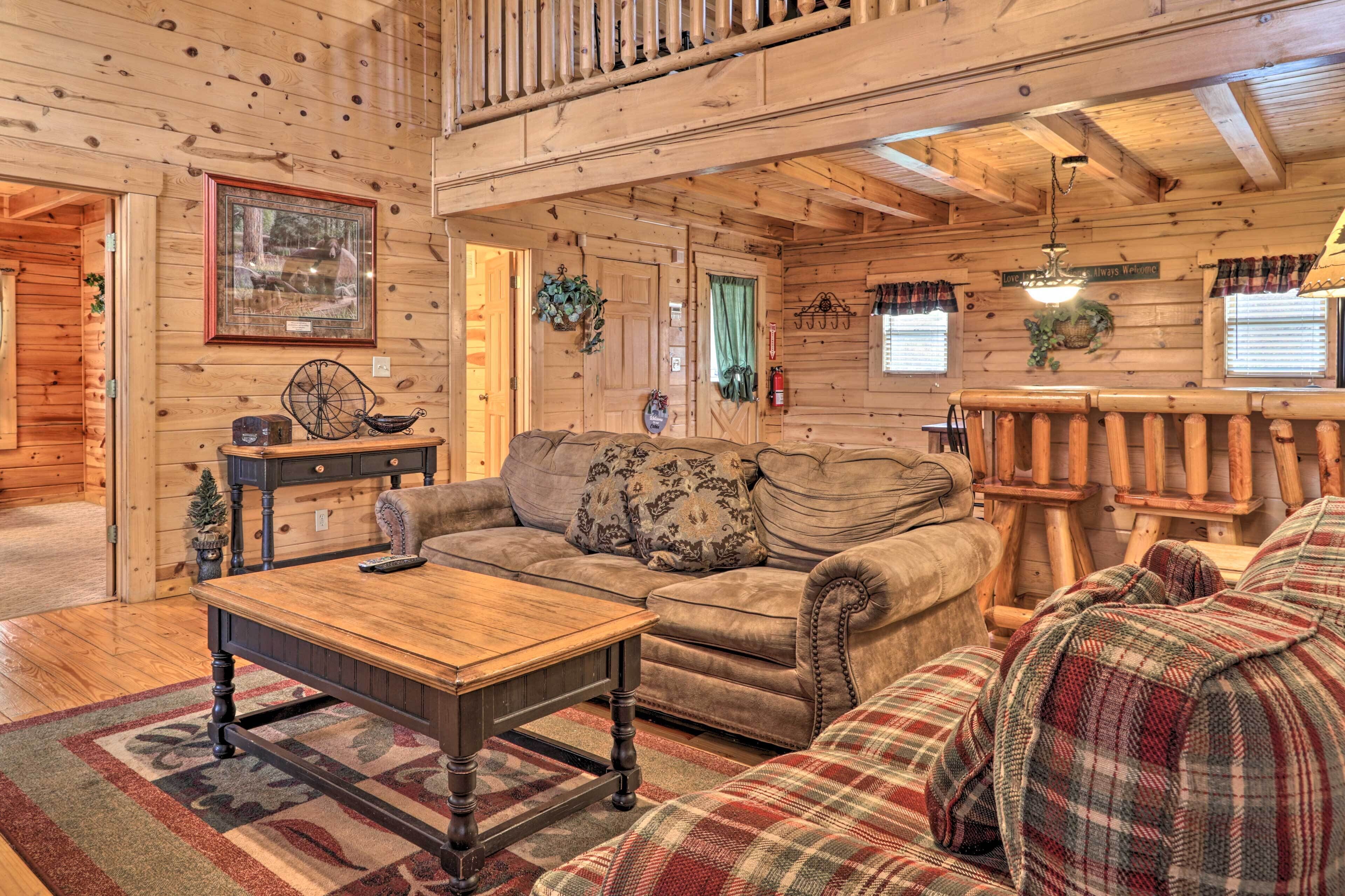A cozy log cabin interior with a wooden dining table, a sofa, and a couch.
