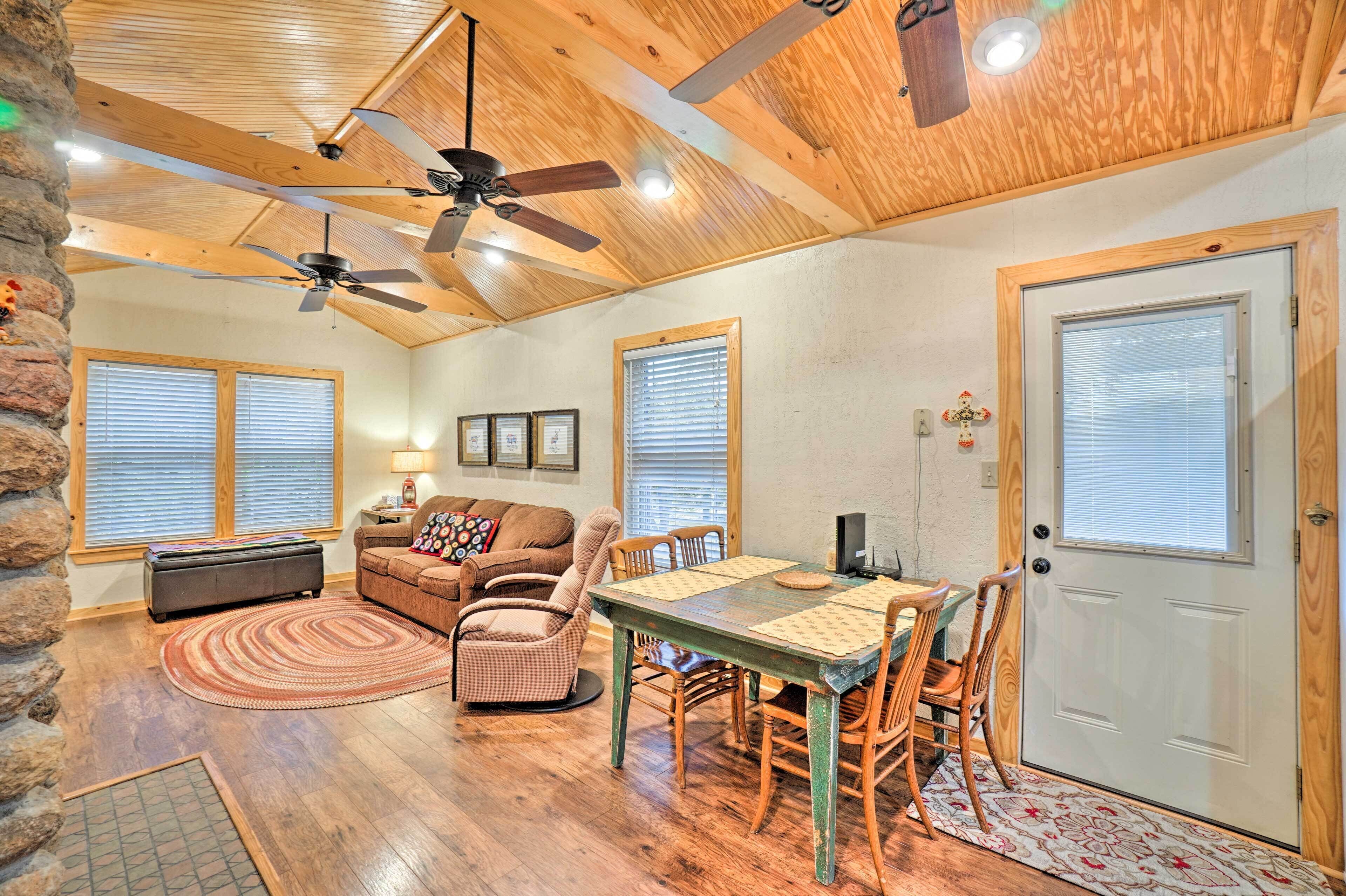 A cozy living room with a fireplace, a dining area with a table and chairs, and a door with a window.