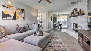 A modern living room with a sectional sofa, a fireplace, and a dining area. - Duplex w/ Private Yard: 3 Mi to Downtown Loveland! (Loveland)