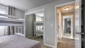 A bedroom with a bunk bed, a walk-in closet, and a door leading to a hallway. - Duplex w/ Private Yard: 3 Mi to Downtown Loveland! (Loveland)