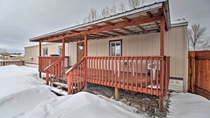 A single-story house with a covered porch and a wooden deck. - Columbia Falls Home ~ 22 Mi to Glacier Natl Park! (Columbia Falls)