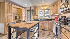 Una cucina con mobili in legno, un tavolo da pranzo in legno e un forno integrato.