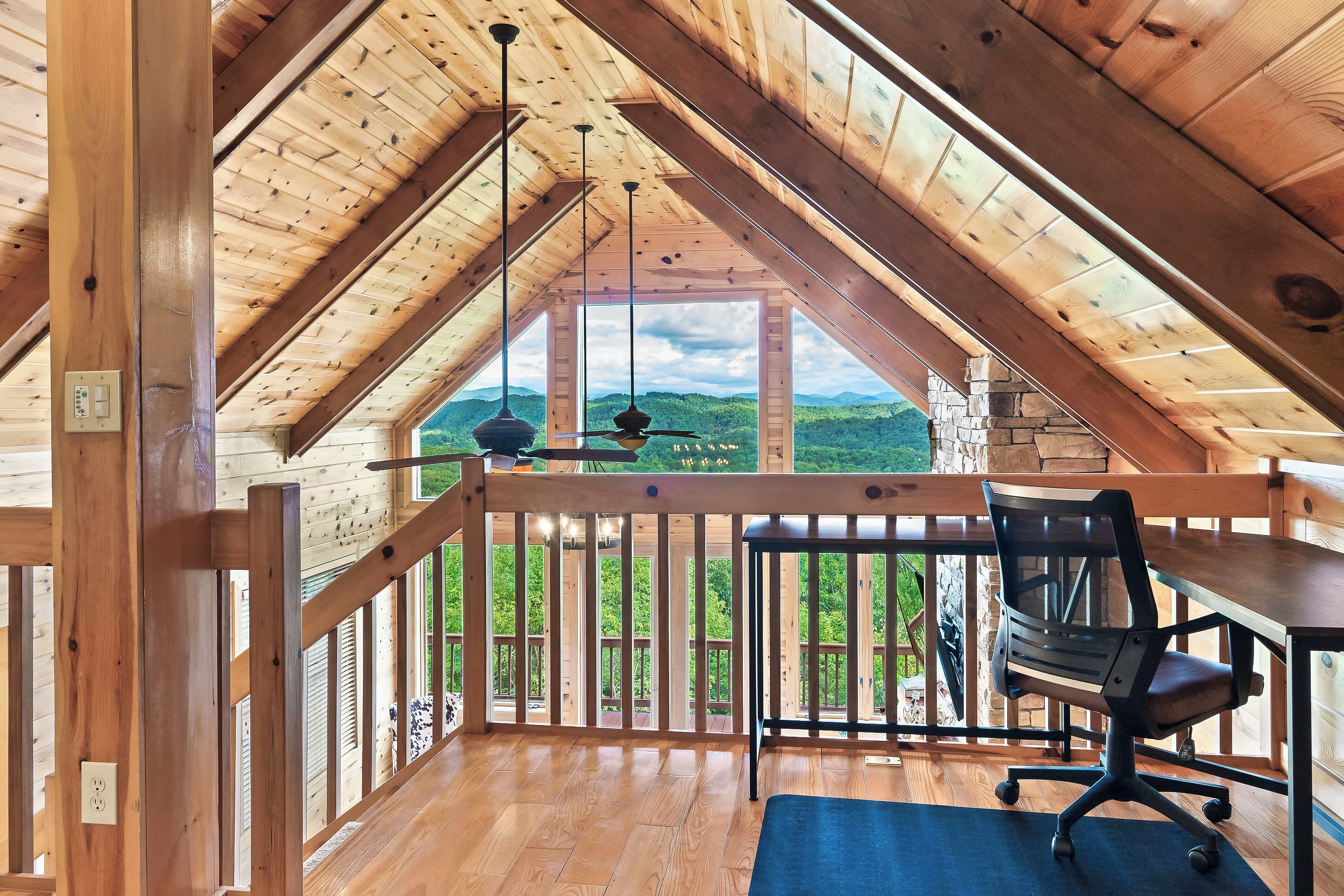 Een houten interieur met een balkon met uitzicht op een groen landschap.