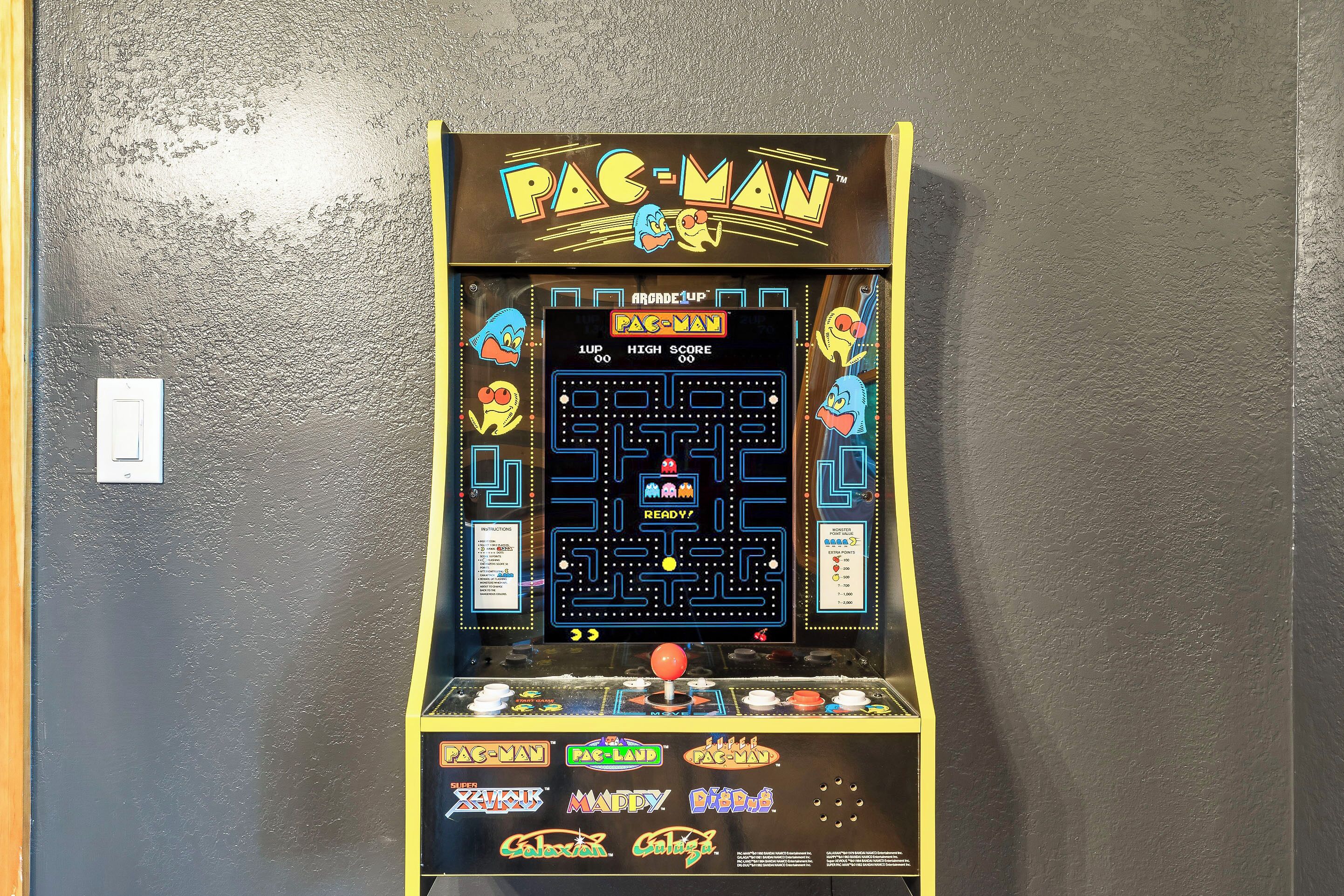 A Pac-Man arcade machine with a high score display, game controls, and various Pac-Man themed labels.