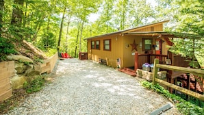 A cabin with a gravel driveway, wooden deck, and a star decoration on the front. - Hot Tub Private Mtn-view Deck Family Cabin (Almond)