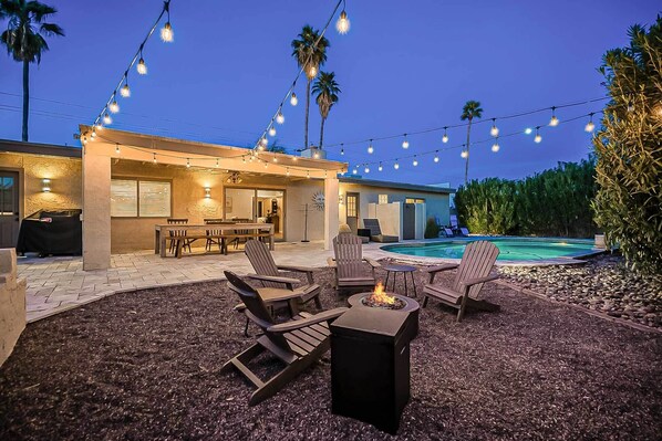 An outdoor patio area with string lights, a pool, and outdoor furniture. - Scottsdale Adobe Home w/ Backyard Oasis! (Scottsdale)