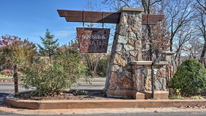 A stone pillar with a sign reading "TAN-CA-ESTATES" and a metal roof structure.
