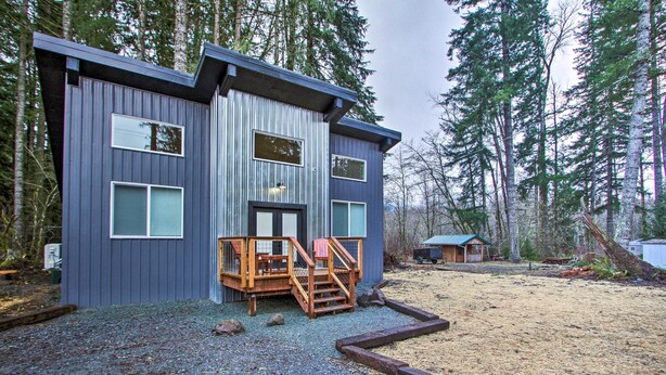 A modern cabin with a wooden deck and a small porch, surrounded by a forest. - Home w/ Hot Tub < 5 Miles to Rainier National Park (Mineral)