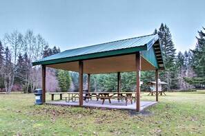 A covered picnic area with benches and picnic tables, surrounded by trees. - Home w/ Hot Tub < 5 Miles to Rainier National Park (Mineral)