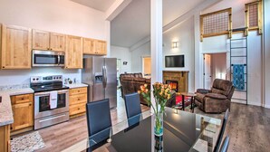 A modern kitchen with wooden cabinets, stainless steel appliances, and a dining area with a glass table and chairs. - Home w/ Hot Tub < 5 Miles to Rainier National Park (Mineral)