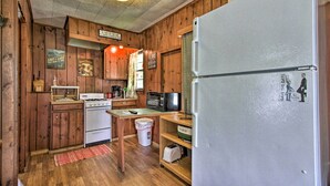 A kitchen with wooden cabinets, a stove, a microwave, a refrigerator, and a sink. - Dent Cabin on Star Lake w/ Dock, Deck, Dining (Dent)