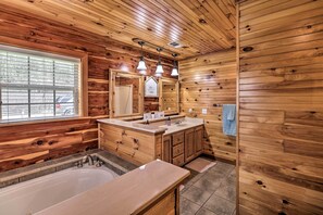 A wooden cabin bathroom with a bathtub, double sink vanity, and a large mirror. - 'marfly Retreat' - Remote White River Getaway! (Mountain View)