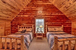 A log cabin bedroom with two wooden beds, a window with blinds, and a small table with a lamp. - 'marfly Retreat' - Remote White River Getaway! (Mountain View)