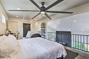 A bedroom with a large bed, a ceiling fan, and a balcony with a railing. - Fire Pit, Deck & Mtn Views: Upscale Pine Cabin! (Pine)