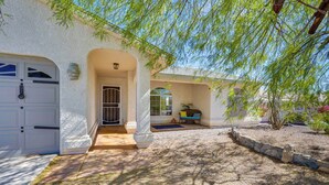 A house with a covered entryway, a stone pathway, and a patio area with a bench. - Lake Havasu Getaway w/ Pool, Hot Tub & Game Room (Lake Havasu City)