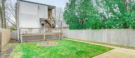 A two-story house with a deck and a fenced backyard.