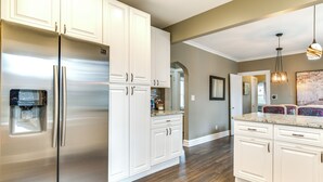 A kitchen with white cabinetry, stainless steel appliances, and a marble countertop. - Pet-friendly Family Apartment - Near NU Campus! (Evanston)