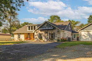 Une maison à deux étages avec un porche à l’avant, un garage et une allée.