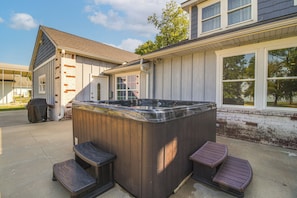 Un bain à remous avec deux marches et une terrasse en bois.