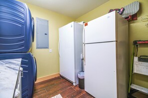 Una cocina compacta con refrigerador, microondas y pileta.