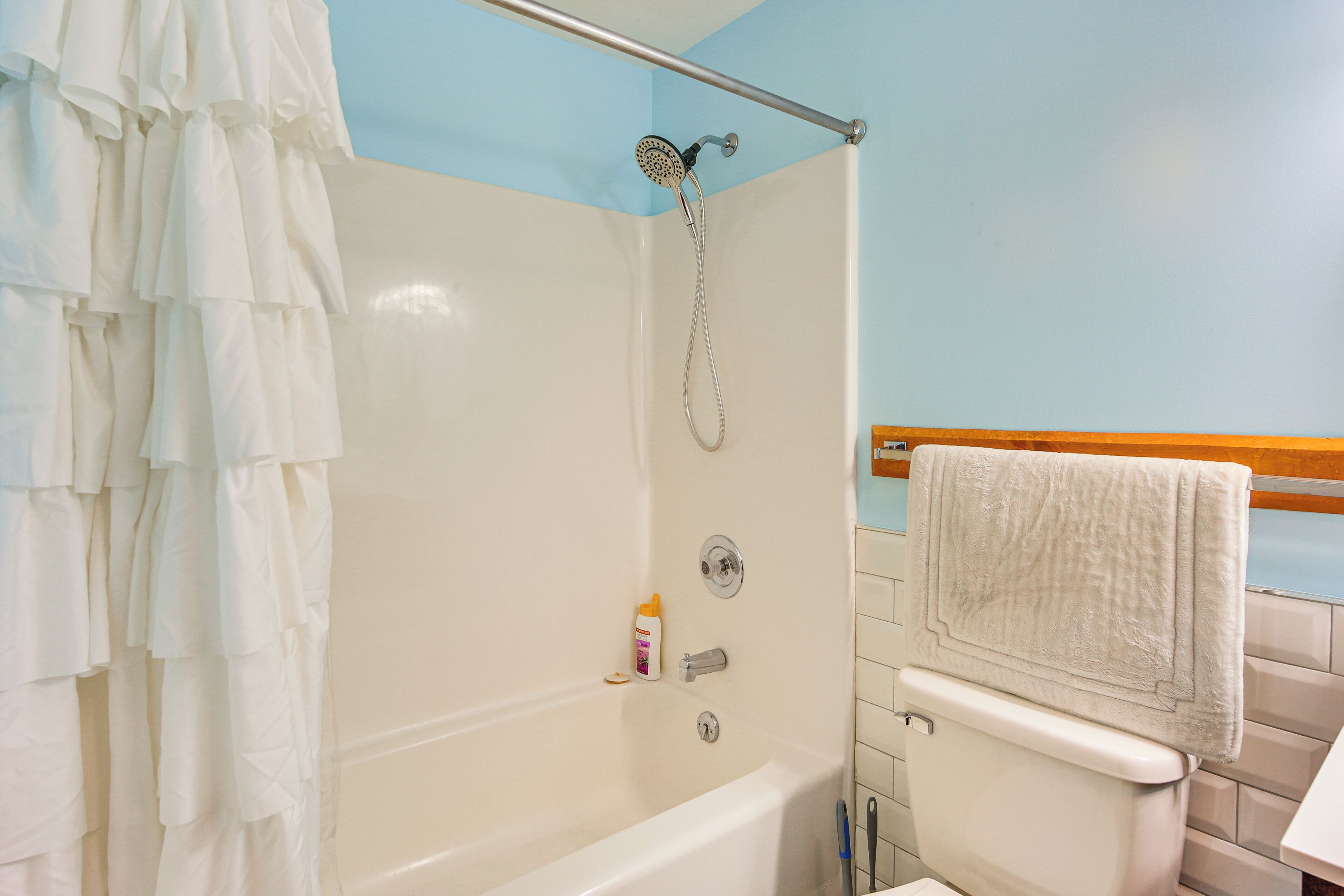 Un bagno con vasca, doccia, WC e portasciugamani.