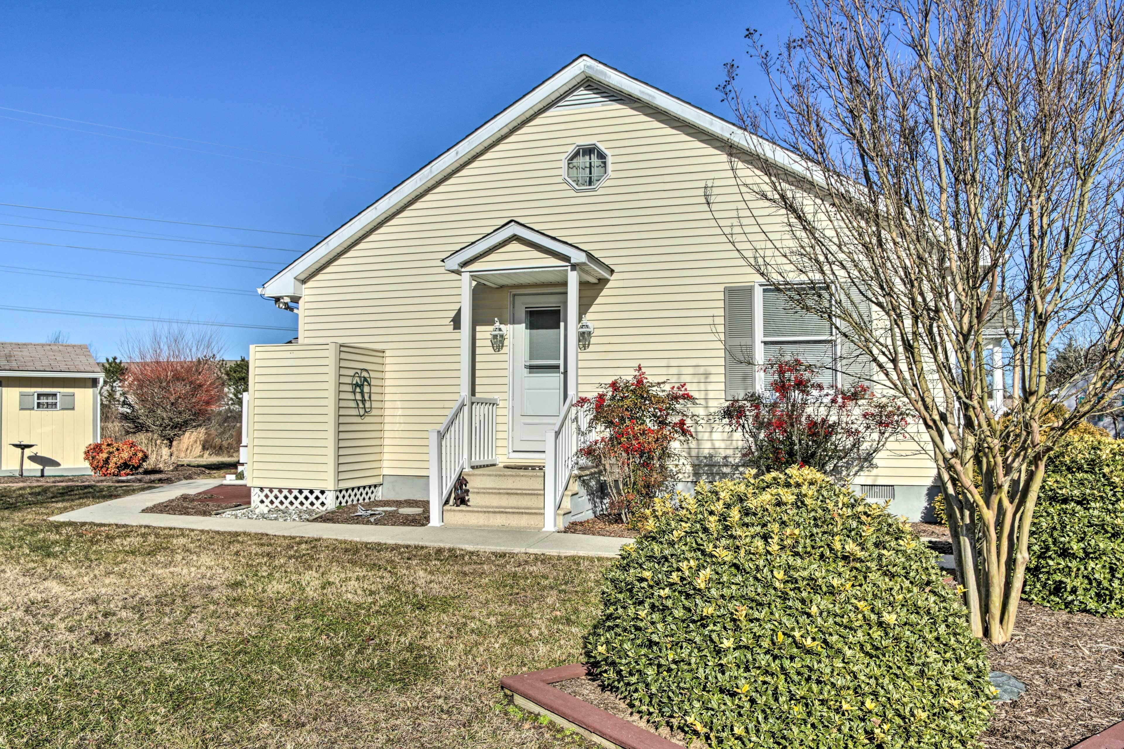 A single-story house with a front porch, a small staircase, and a well-maintained lawn.