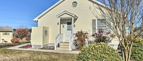 A single-story house with a front porch, a small staircase, and a well-maintained lawn.