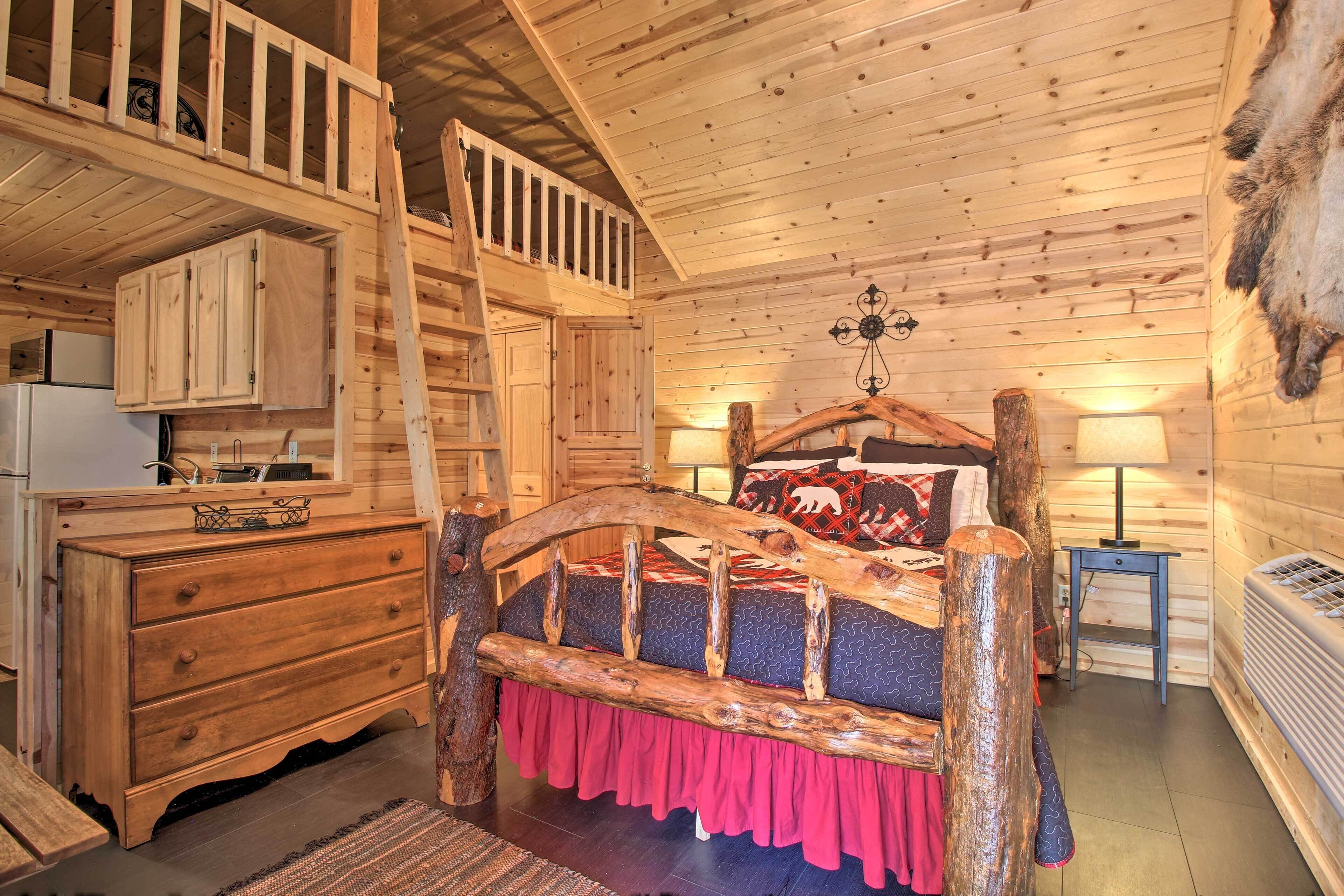 A log cabin room with a loft bed, wooden furniture, and a fur rug.