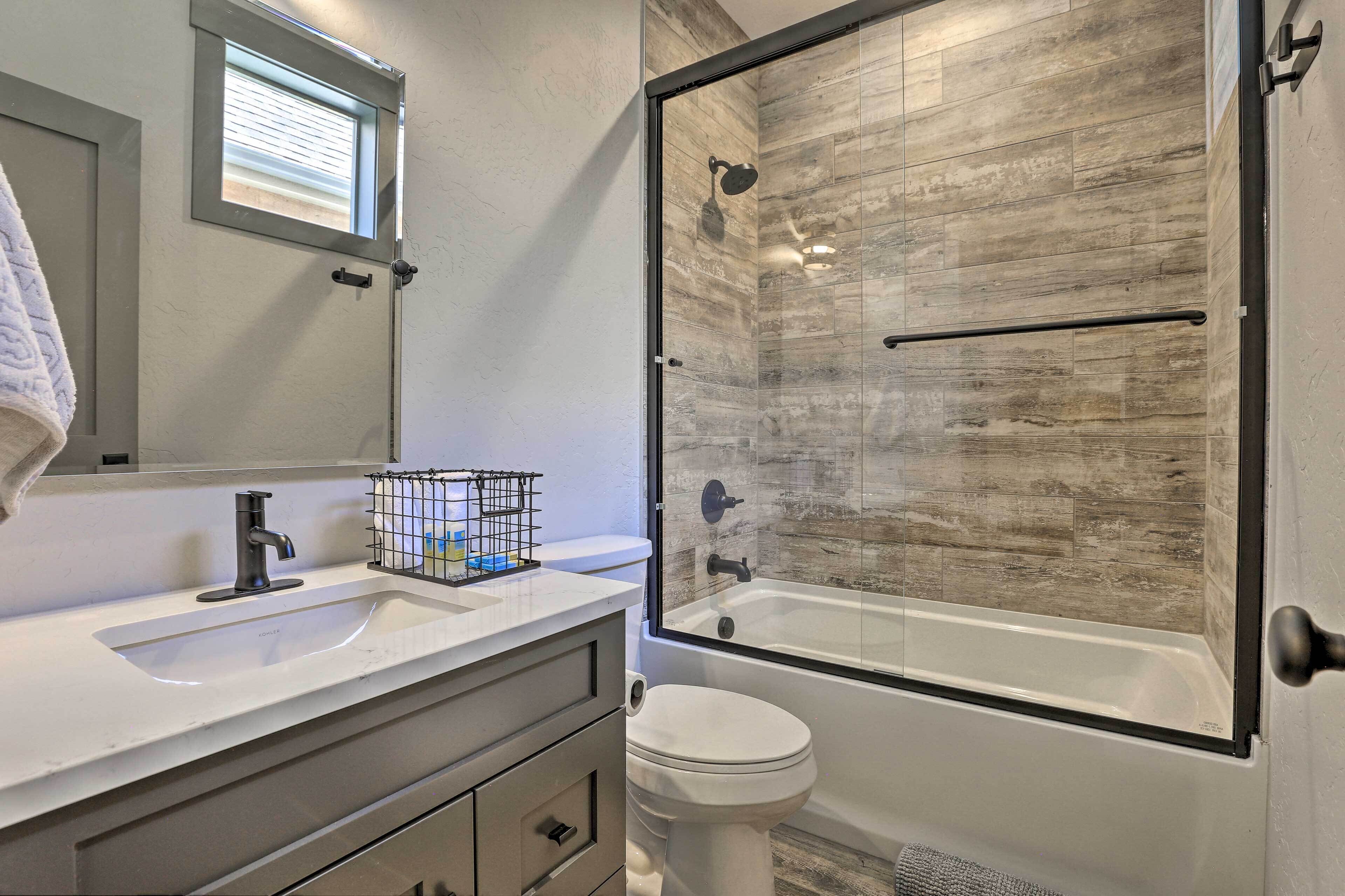 A modern bathroom with a large shower, a sink, and a toilet.