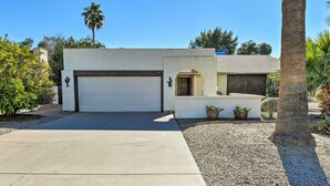 A modern house with a garage, a small patio area, and a palm tree. - Golf, Hike & Suntan: Mesa Family Home w/ Yard (Mesa)