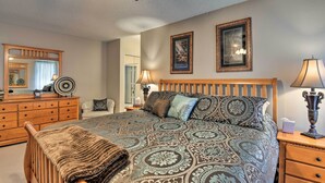 A bedroom with a large bed, wooden headboard, two bedside tables with lamps, a dresser, a mirror, and two framed pictures on the wall. - Golf, Hike & Suntan: Mesa Family Home w/ Yard (Mesa)