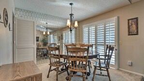 A dining area with a round table and six wooden chairs, a chandelier, and a hexagonal patterned wall. - Golf, Hike & Suntan: Mesa Family Home w/ Yard (Mesa)