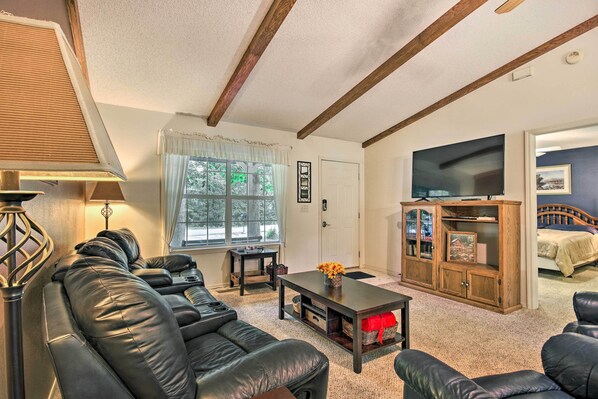 A living room with a sofa, coffee table, TV, and a cabinet.