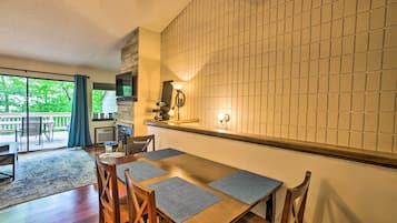 A dining area with a wooden table, chairs, and a tiled backsplash.
