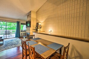 Un comedor con una mesa de madera, sillas y un salpicadero de azulejos.