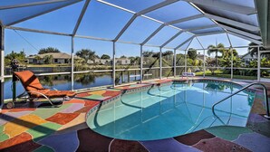 A covered outdoor swimming pool with a clear view of the surrounding area, including a body of water and distant buildings.