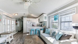 A spacious kitchen with white cabinets, a central island, and blue barstools. - 2.5 Blocks to Beach! Miramar Tropical Cabana' (Miramar Beach)