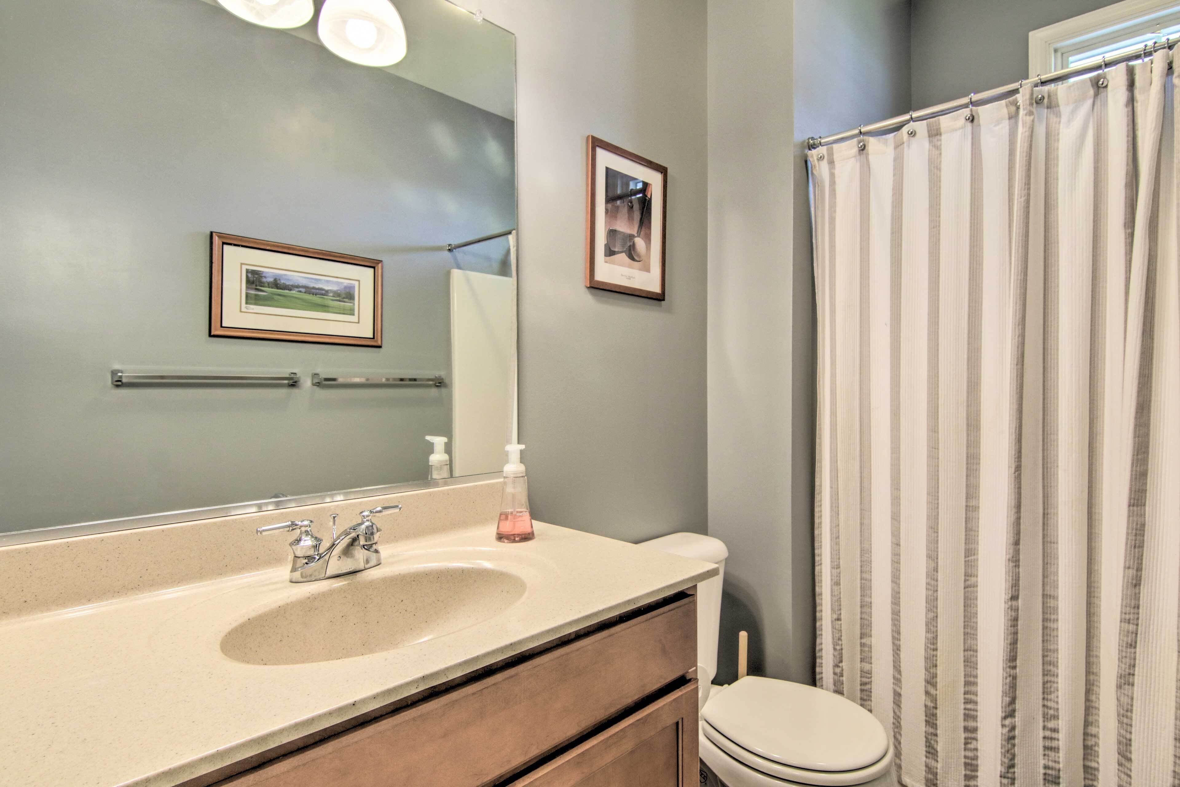 A bathroom with a sink, mirror, and toilet.
