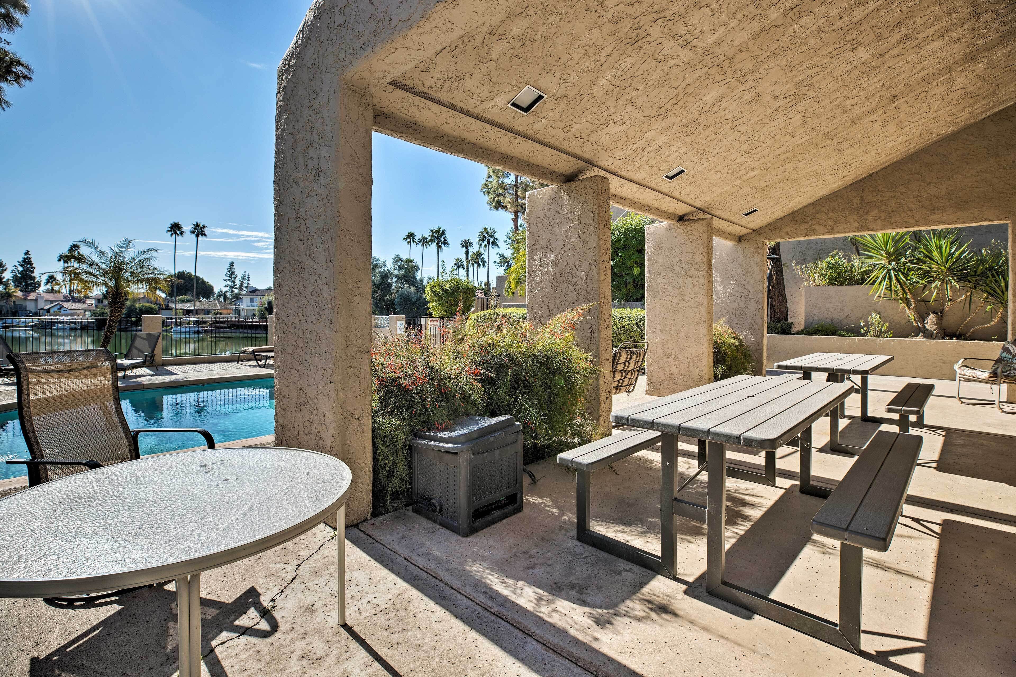 An outdoor patio area with a pool, seating, and a view of the surrounding landscape.