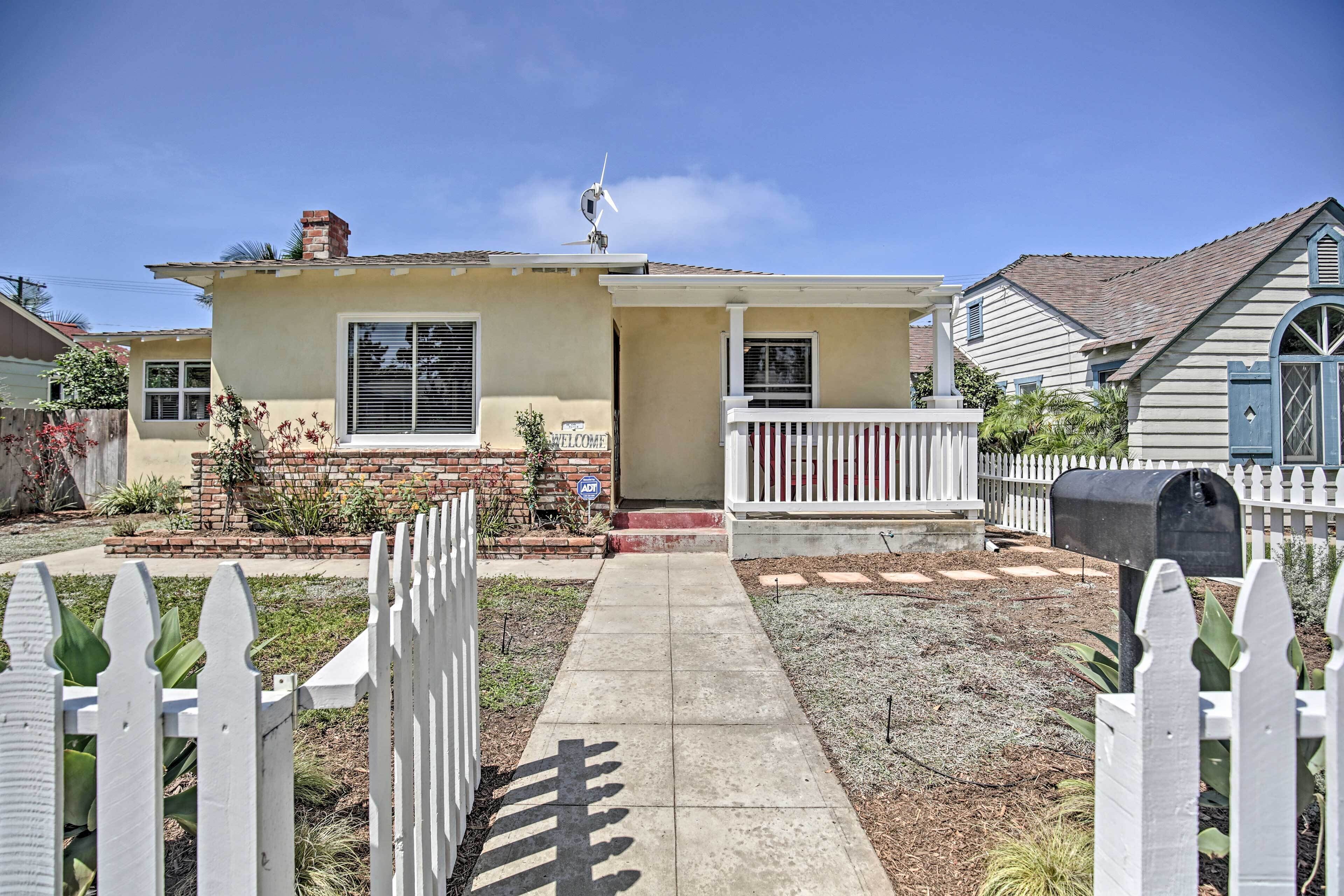 A single-story house with a front porch, a mailbox, and a small garden.