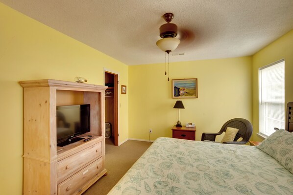 A bedroom with a bed, a wooden TV stand, a ceiling fan, and a window with blinds. - Downtown Home w/ Yard & BBQ - 6 Mi to Downtown! (Beaufort)