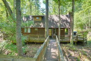 A cabin with a wooden deck, a covered porch, and a staircase leading to the entrance. - Cozy Cabin Near Massanutten Resort & Water Park! (McGaheysville)