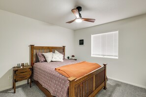 A bedroom with a wooden bed, a nightstand, a ceiling fan, and a window with blinds. - 2 Mi to Beach: Lake Havasu Gem w/ Pool & Spa! (Lake Havasu City)