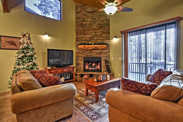 A cozy living room with a fireplace, a Christmas tree, and comfortable seating. - Mountain Cabin Retreat w/ Game Room, Patio & Views (Pinetop)