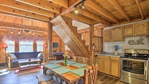 Un intérieur en bois comprenant un coin repas, une cuisine et un escalier.