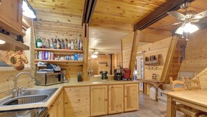 A wooden cabin interior with a kitchen area featuring a sink, cabinets, a microwave, and a coffee maker. - Near Hiking & Golfing: Munds Park Cabin w/ Deck! (Munds Park)