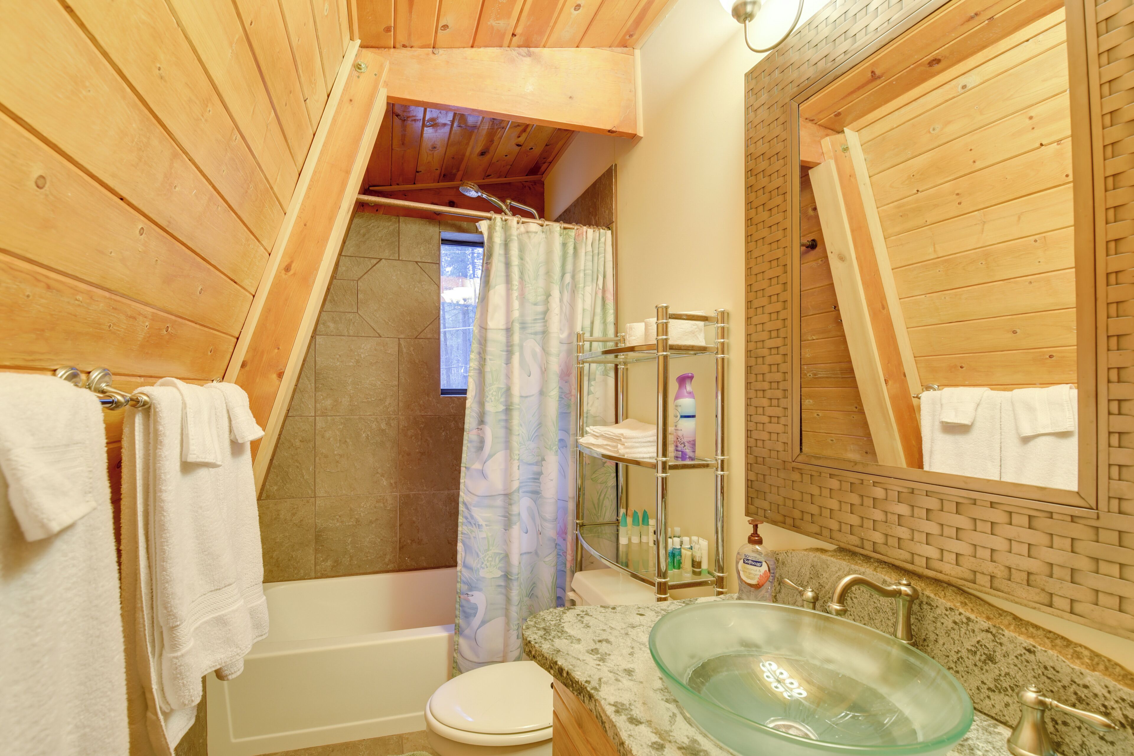Une salle de bain avec un lavabo en verre, une baignoire, des toilettes et un espace douche.